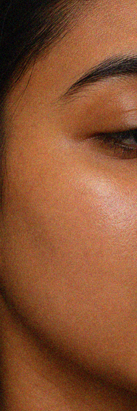 Close-up of cheek skin showing a smooth, even-looking texture with a natural glow and less visible redness.